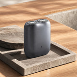 Xiaomi Pocket Electric Travel Shaver (S200) in grey with dual circular shaving foils on a wooden travel desk
