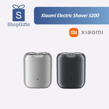 Xiaomi Pocket Electric Travel Shaver (S200) in grey with dual circular shaving foils on a wooden travel desk