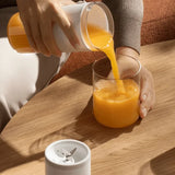Xiaomi 300ml Portable Blender  with a transparent cup and silicone sleeve for oren smoothies.