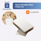 Xiaomi Portable Photo Printer Pro (KDRSHDY03HT) in white beside printed snapshots.